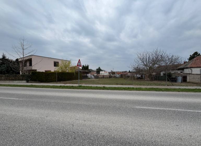 Plots - housing on Hlavná Street in Mojzesovo with gardens and a building nearby.
