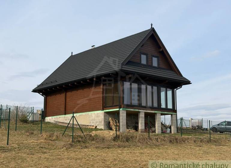 A family house in Lom nad Rimavicou with wooden cladding and a glass veranda.