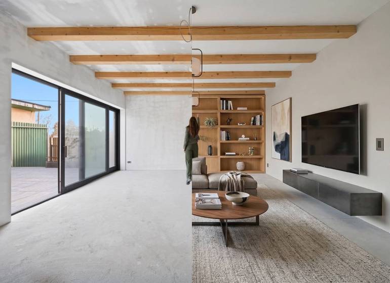 Living room in a family house with wooden beams and large glass doors.
