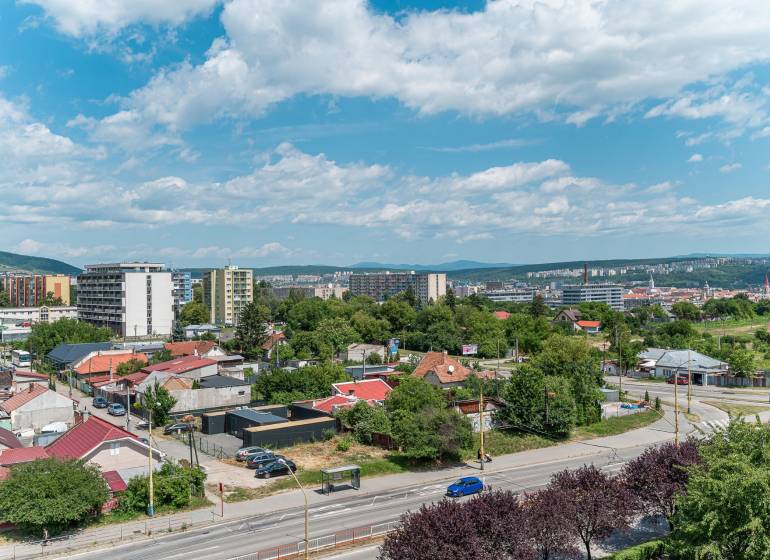 View from Pražská Street in Košice, Západ district, towards greenery and buildings.