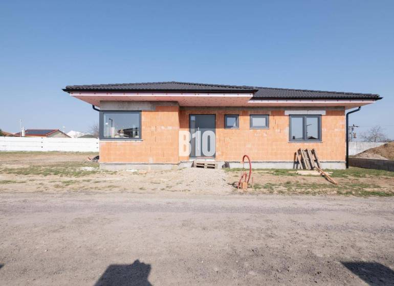 A family house in Veľký Lapáš with raw brick walls and a sloped roof.