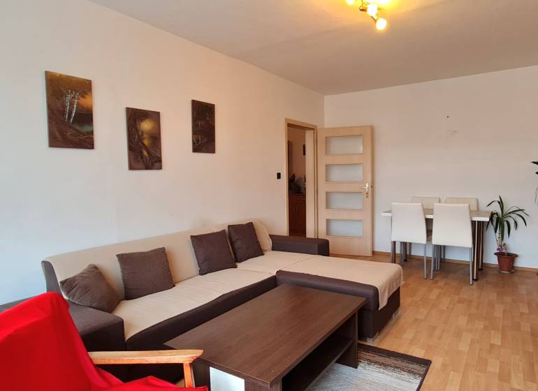 Living room with a corner sofa, floor with wood decor, and wooden furniture.