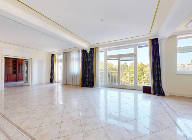 A spacious living room with large windows in a 5 or more room apartment.