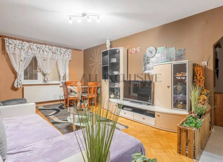 Living room in a 3-room apartment with a wooden decor floor and a comfortable sofa.
