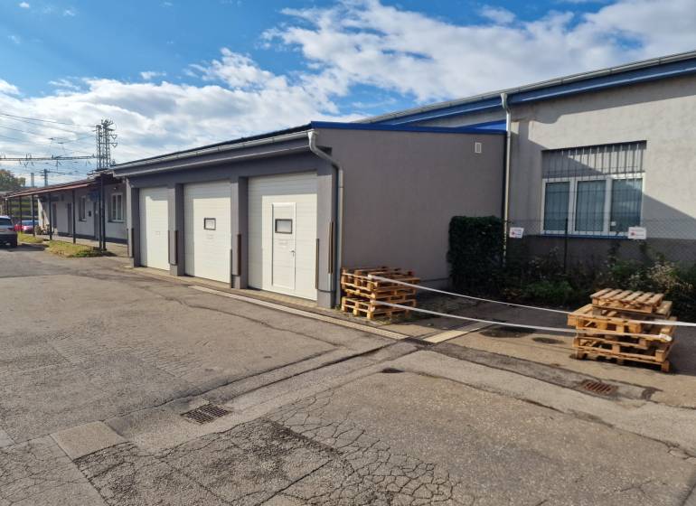 A building with garage doors, storage spaces near the railway track in Žilina.