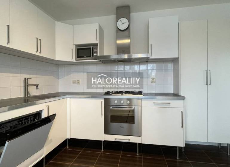 A kitchen in a 3-room apartment with white cabinets and stainless steel appliances.