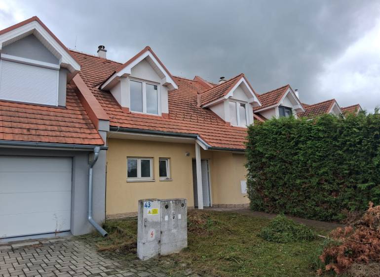 A family house in Ľubela with a red roof, a garage, and a well-maintained garden.