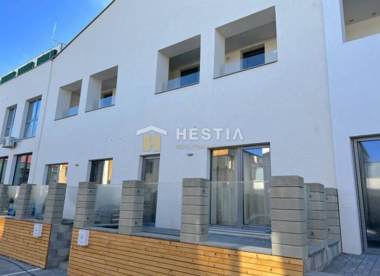 A new building with multiple balconies and a 2-room apartment, a concrete fence, and a terrace.