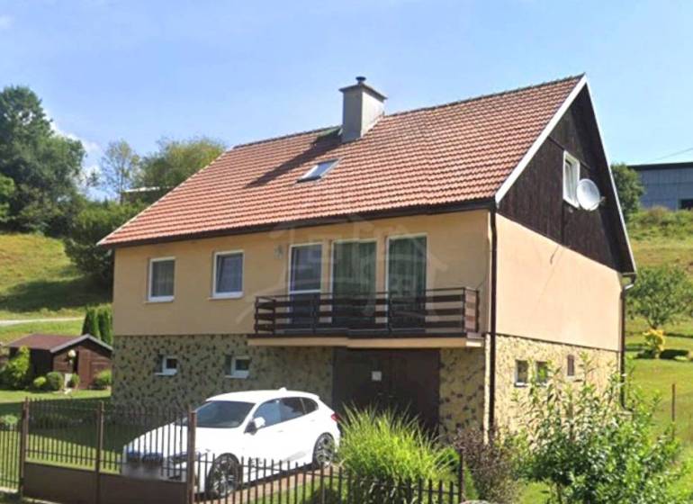 A family house in Liptovské Revúce with a garage and a garden on a sloped plot.