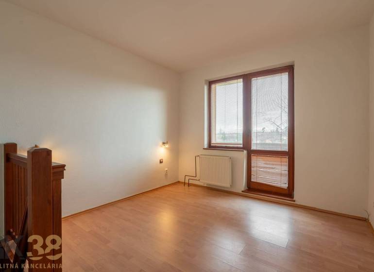 A room with a wooden decor floor in a 5 or more room apartment, light walls, large window.