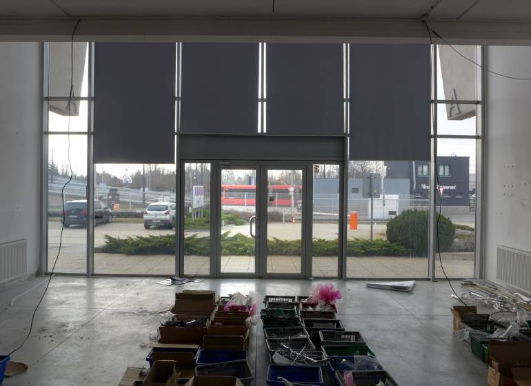 Interior of commercial premises in Bratislava with large glass doors and storage boxes.