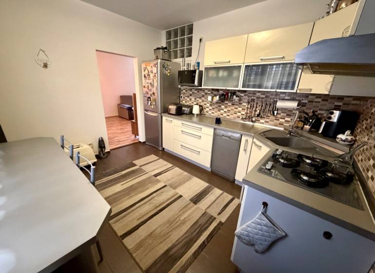 A kitchen in a 3-room apartment with a gas cooktop and tiled backsplash.