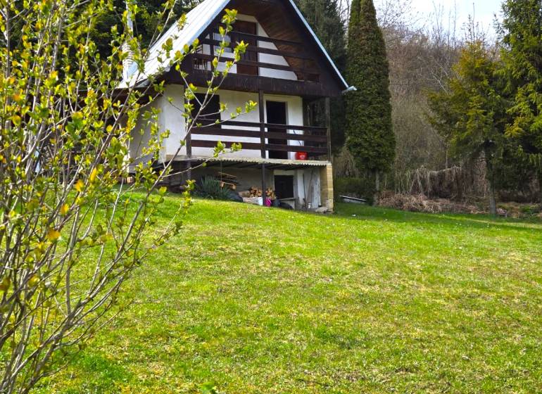 A cottage in Veľký Šariš in a beautiful natural setting surrounded by greenery and trees.