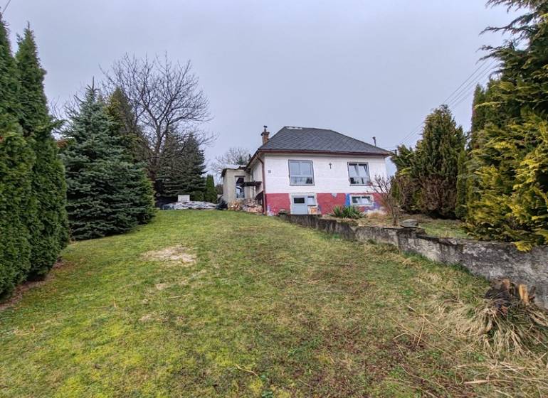 A family house on Hlavná in Piskorovce surrounded by trees and a grassy yard.