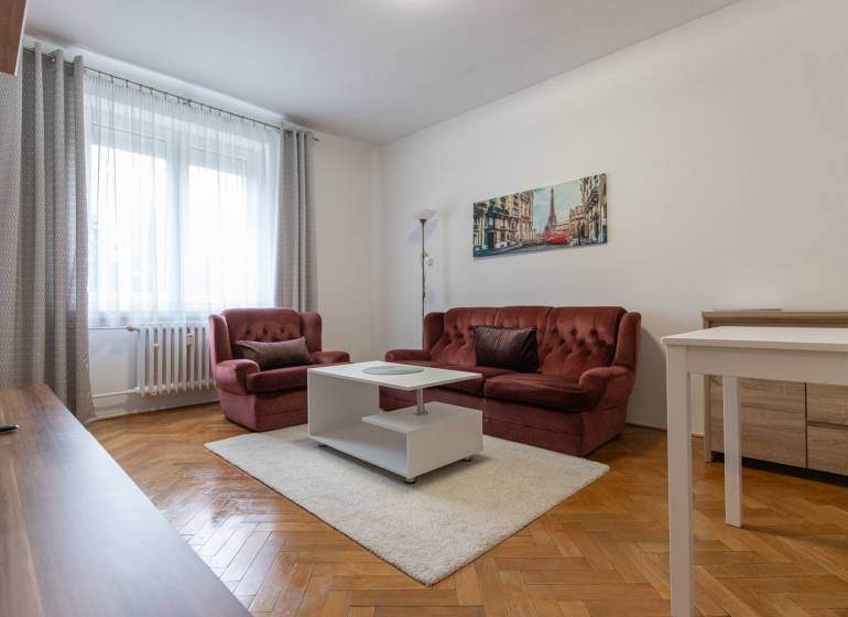 Living room with a red sofa, white table, and wooden decor flooring.
