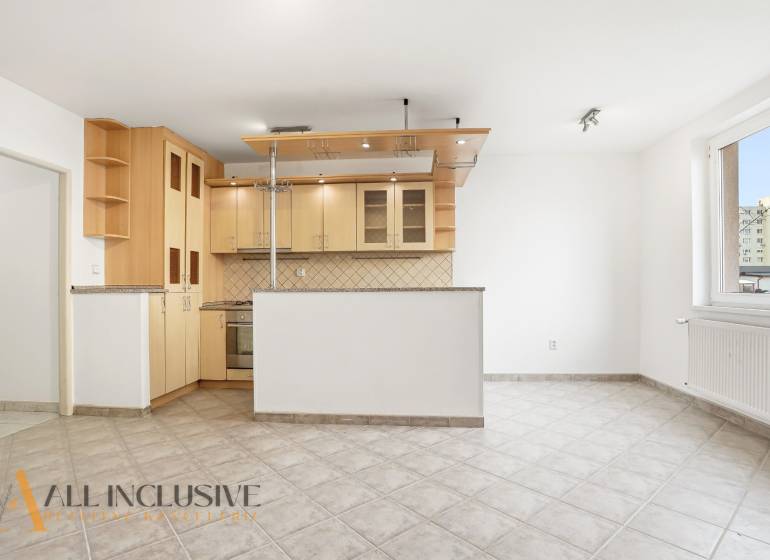 A kitchen with a corner unit in a 2-room apartment, tiled floor, white walls.