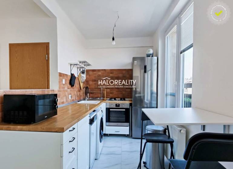 A kitchen with a built-in oven and hob, a floor with a wooden decor, a three-room apartment.