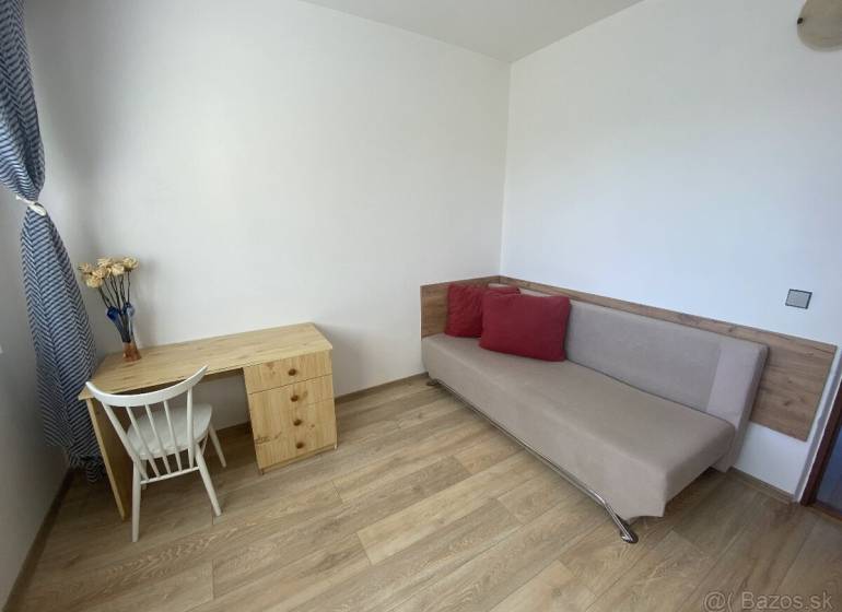 Living room in a 4-room apartment with a table, chair, and sofa. Floor with wood decor.