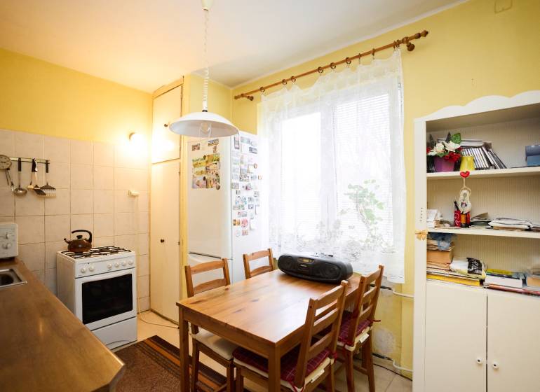 Kitchen in a 3-room apartment with a table, chairs, and a kitchen unit.