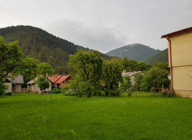 A family house in Blatnica surrounded by green trees and mountains.