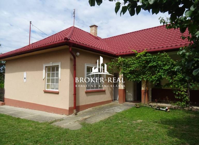 A family house in Goncruszka with a red roof and a green yard.
