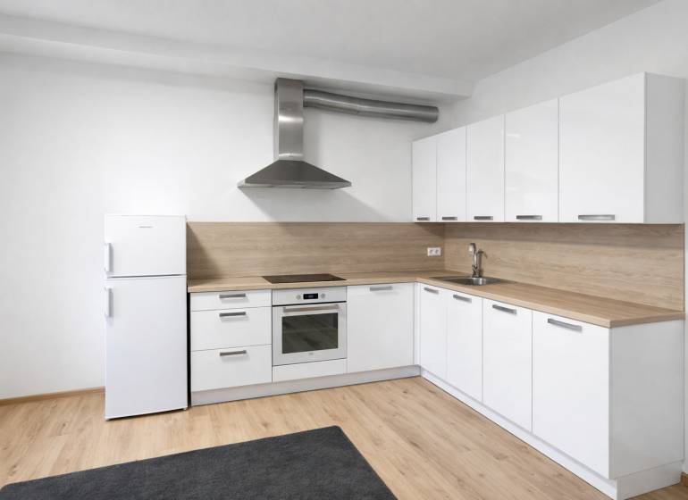 White kitchen, light decor, appliances and wooden decor flooring in a 2-room apartment.