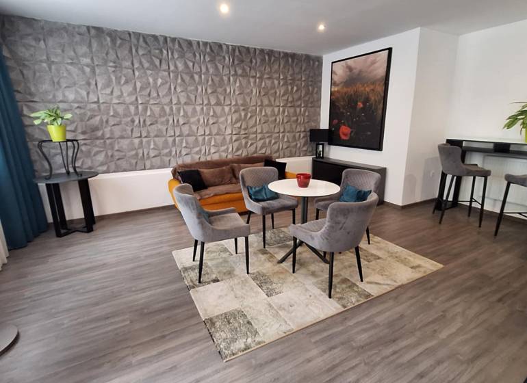 Living room with armchairs and a sofa in a family house, decorative wall and bar corner.