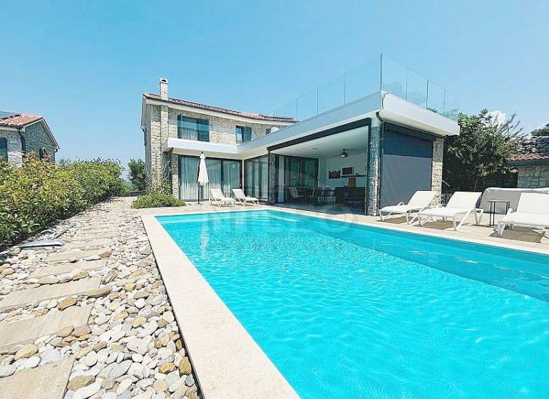 Villa in Jakišnica with a pool and stone terrace, surrounded by greenery.