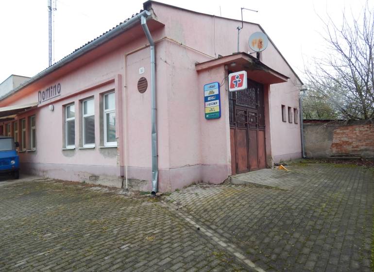 Pink building in Búča with the sign 