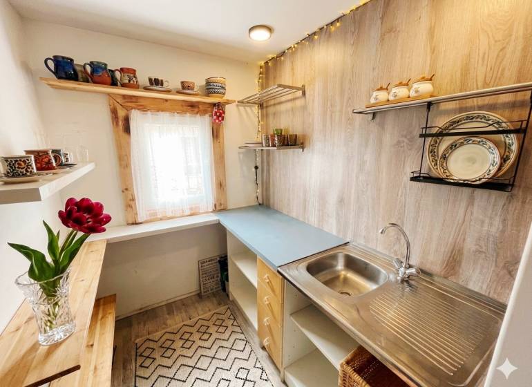 A kitchen in a family house with shelves and a wooden decor floor.