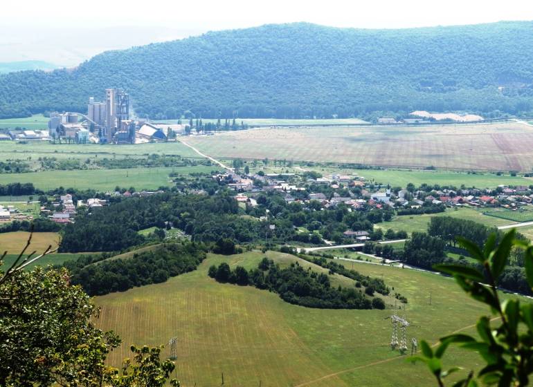 A view of agricultural and forest land in Dvorníky-Včeláre with an industrial area.
