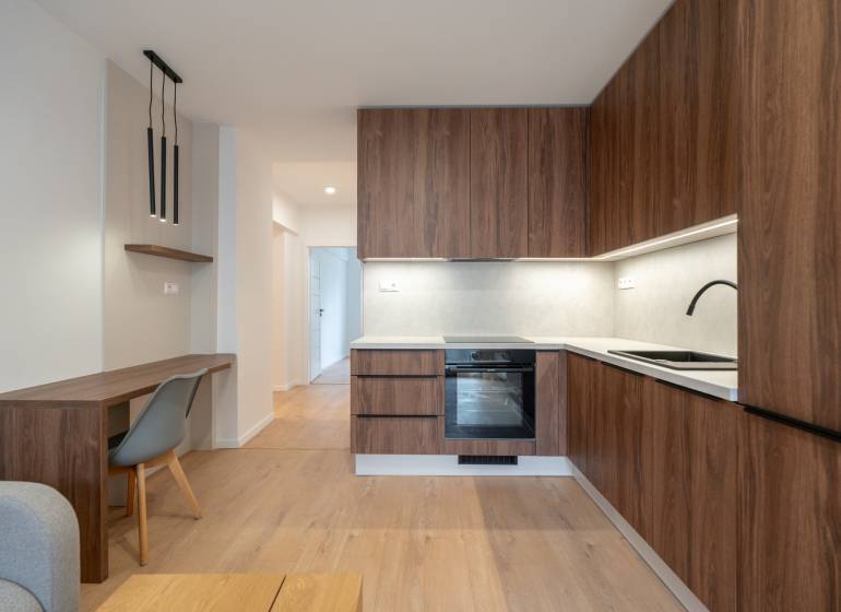 A kitchen in a 3-room apartment with wooden decor and stylish lighting.