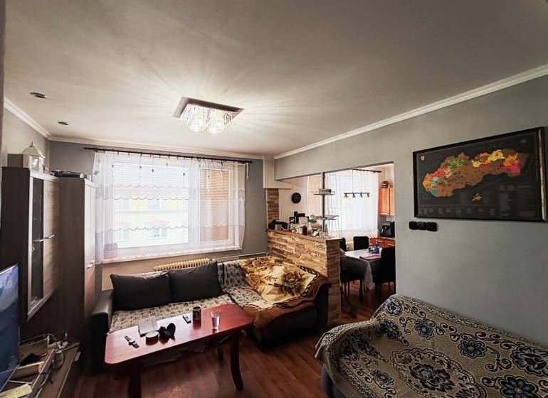 Living room with a sofa set, wooden decor flooring, and a light chandelier in a 4-room apartment.