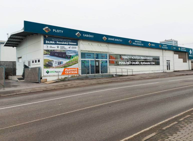 Commercial spaces on Kamenná Street in Žilina with advertising signs and an empty parking lot.