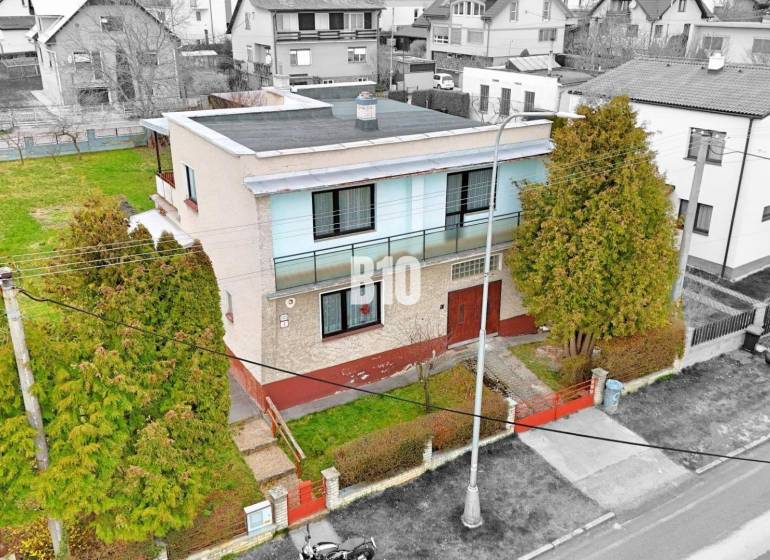 A family house in Martin with a flat roof, a garden, and surrounding houses.