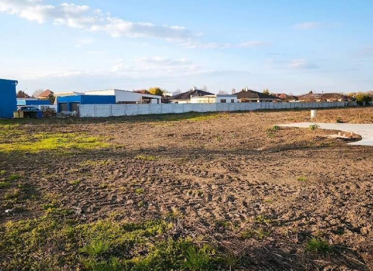 Commercial land in Kráľová nad Váhom with a spacious open area and fenced buildings.