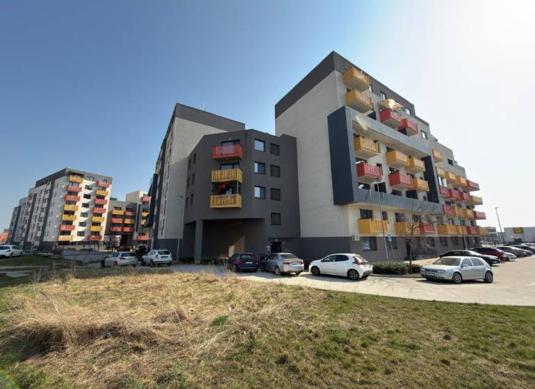 Apartment buildings on Mikovíniho Street in Trnava with a parking lot and green area.