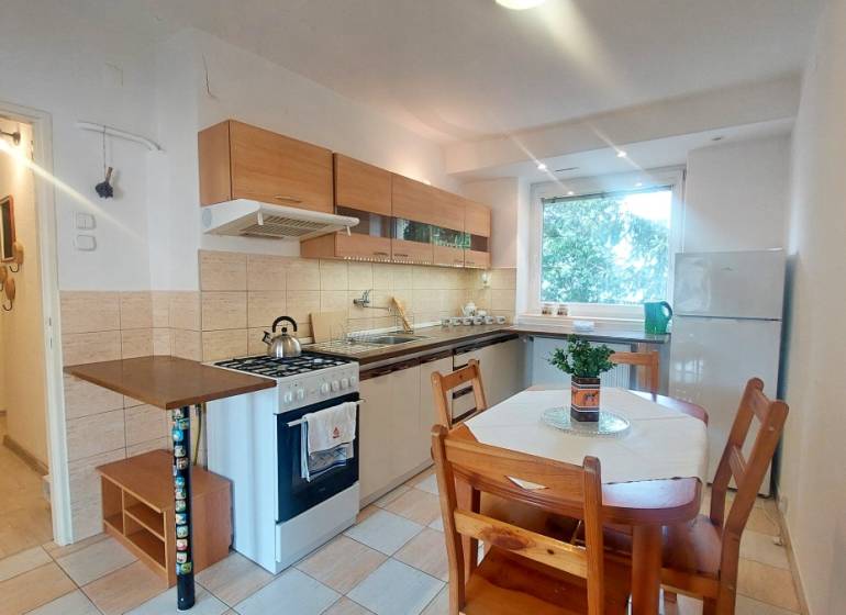 A kitchen with a kitchenette and a dining table in a 2-room apartment.