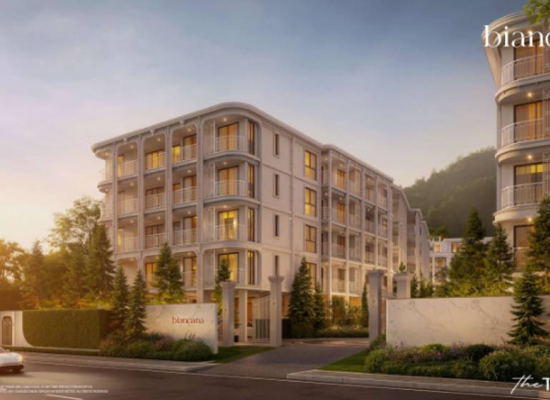 Apartment construction in Phuket, an elegant building surrounded by greenery at dusk.