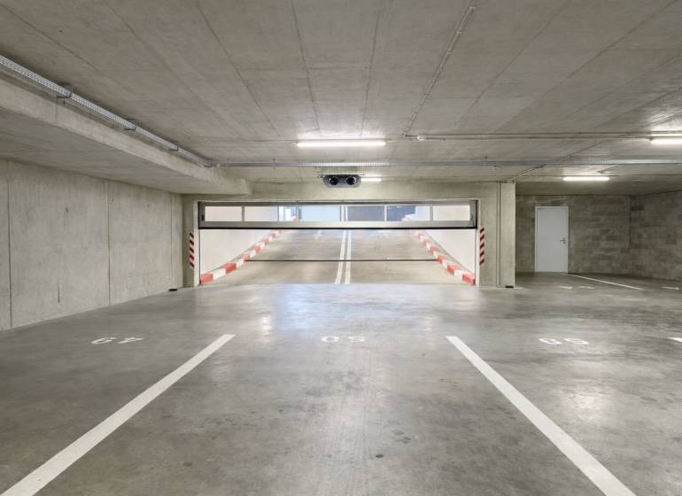 Parking spaces in garages with a ramp and white markings.