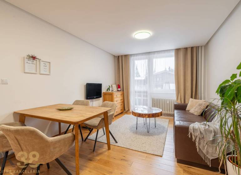 Living room in a holiday apartment with a cozy sofa and a wooden decor floor.