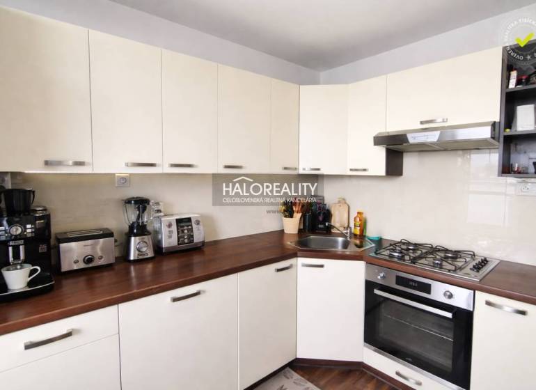 A kitchen in a 4-room apartment with white cabinets and a wood-patterned floor.