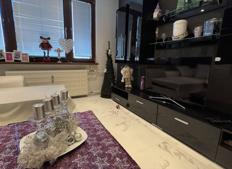 Living room in a two-room apartment with a marble floor and festive decoration.