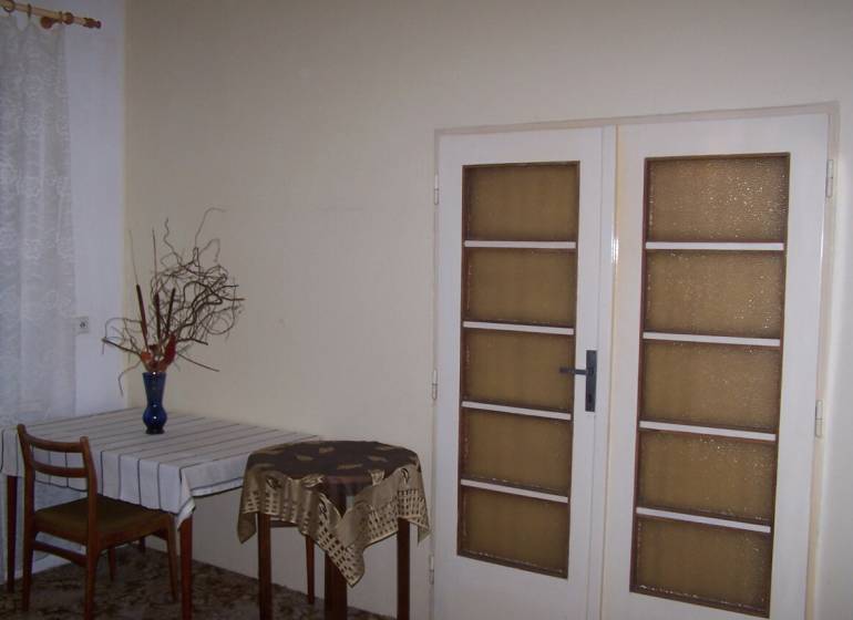 Interior of a 2-room apartment with a dining table and glass doors.