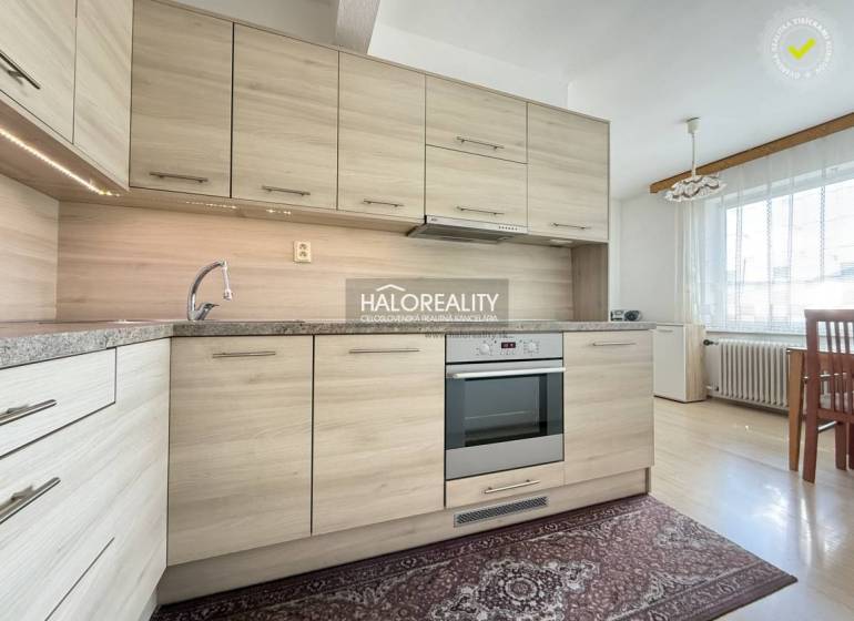A kitchen in a family house with a wooden decor floor and a modern kitchen unit.