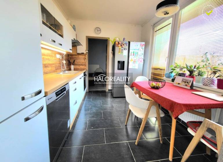 A kitchen in a 3-room apartment with tiles and wooden decor, bright and spacious.