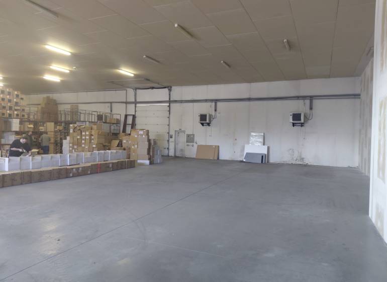 Spacious interior of warehouses and halls with cardboard boxes and workers.