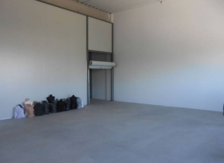 Spacious interior of warehouses and halls with concrete floor and bags along the wall.