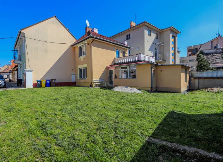 A family house on Hviezdoslavova Street in Piešťany with a grassy yard and a bench.