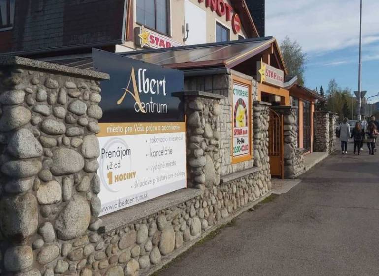 Offices in Poprad with a stylish stone facade and an advertisement for space rental.